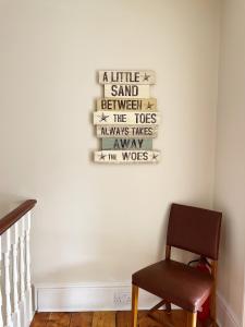 a chair sitting next to a wall with a sign on it at The Anchorage , Gorleston on Sea in Gorleston-on-Sea