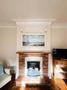 a living room with a fireplace with a painting on the wall at The Anchorage , Gorleston on Sea in Gorleston-on-Sea