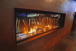 a brick fireplace with a fire in it at Mamma Mia Hotel Boutique - Only Adults in Tossa de Mar