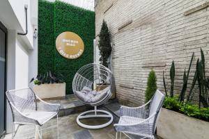 un patio avec trois chaises, une table et un panneau dans l'établissement Vivotel Boutique, à Guatemala