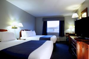 a hotel room with two beds and a flat screen tv at St Christopher's Hotel in Channel-Port aux Basques +27 photos