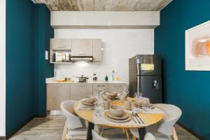 a dining room with a table with chairs and a kitchen at Vivotel Boutique in Guatemala