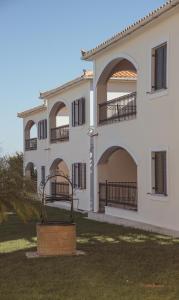 a large white building with balconies and a yard at Erietta Apartments in Tsilivi