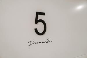 a black number on a white wall at Mamma Mia Hotel Boutique - Only Adults in Tossa de Mar