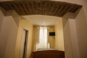 a room with a bed and a window with a curtain at Hospedaria Santa Maria in Beja +53 photos