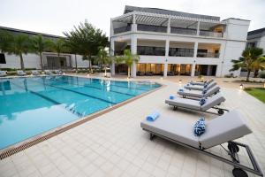 Una piscina con tumbonas frente a un edificio. en Imperial Plaza Hotel, Juba, en Yuba