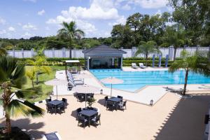 a pool with tables and chairs and a gazebo at Imperial Plaza Hotel & Resort Juba in Juba