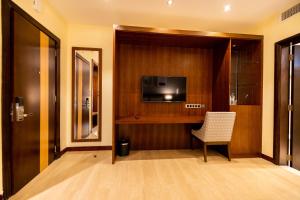 a room with a door with a chair and a television at Imperial Plaza Hotel & Resort Juba in Juba