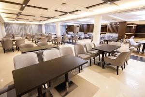 Imperial Plaza Hotel & Resort Juba في جوبا: قاعة اجتماعات مع طاولات وكراسي في مبنى