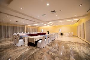a conference room with a long table and white chairs at Imperial Plaza Hotel, Juba in Juba +58 photos