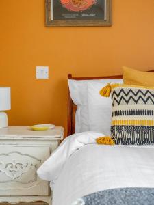 1 dormitorio con 1 cama y mesa auxiliar con lámpara en Cheerful Stays: 4 Bedroom Cottage in Arrochar, en Arrochar