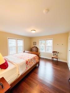 a bedroom with a bed and two windows at State Street Cottage, Suite 2 in Pullman