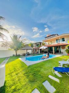 a house with a yard with a swimming pool at Casa de Praia, Paraíso de Tabuba! in Barra de Santo Antônio