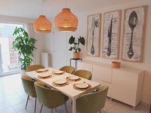 una sala da pranzo con tavolo e sedie bianchi di Sea & the City a Blankenberge