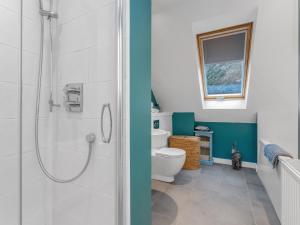 y baño con ducha y aseo. en Cheerful Stays: 4 Bedroom Cottage in Arrochar, en Arrochar