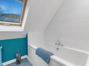 Un baño con bañera y ventana. en Cheerful Stays: 4 Bedroom Cottage in Arrochar, en Arrochar 88 fotos más
