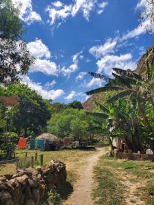 a dirt road through a village with a blue sky at The Hub - Centro Sakbe in San Juan La Laguna