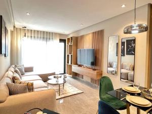 a living room with a couch and a tv at Centro 2 Bedrooms- By AppartAli in Casablanca