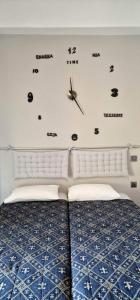 a bedroom with a bed and a clock on the wall at Diana in Ermoupoli