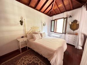 um quarto com uma cama branca e uma janela em Casa Guergue by VV Canary Ocean Homes em Masca