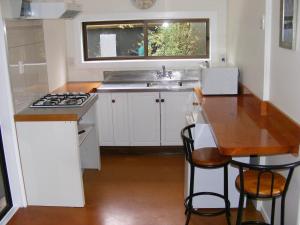 a small kitchen with a sink and a stove at Posto Bello in North Loburn