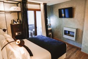 Schlafzimmer mit einem Bett, einem Kamin und einem TV in der Unterkunft Mamma Mia Hotel Boutique - Only Adults in Tossa de Mar