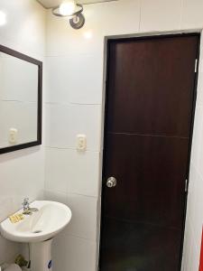 a bathroom with a sink and a shower with a mirror at Hotel Bisou in Cali