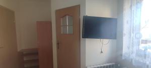 a flat screen tv on a wall next to a door at Domek nad wodospadem in Zakopane