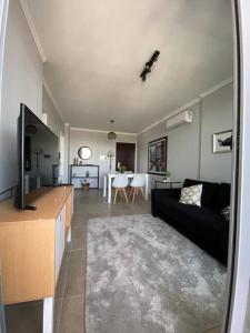 ein Wohnzimmer mit einem schwarzen Sofa und einer Küche in der Unterkunft Moderno Departamento en excelente zona. in Santa Fe