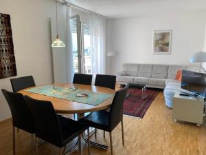 Sonnige 35 Zi-Ferienwohnung in Caslano في كاسلانو: غرفة معيشة مع طاولة وكراسي وأريكة