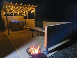 a patio with a bench and a table with lights at Killeavy Cottage in Meigh