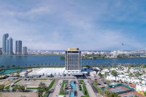 a tall white building next to a body of water at Hotel Holiday International in Sharjah