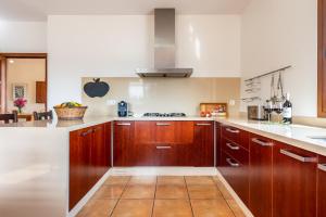 a kitchen with wooden cabinets and white counter tops at Villa Can Jaume Arabí de Baix in Puig D’en Valls