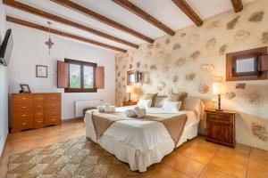 - une chambre avec un grand lit dans l'établissement Villa Can Jaume Arabí de Baix, à Puig D’en Valls