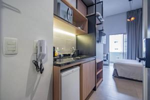 una pequeña cocina con fregadero y nevera. en Estudio Moderno - Vila Madalena, en São Paulo