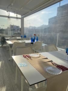 a dining room with tables and chairs and a large window at Mamma Mia Hotel Boutique - Only Adults in Tossa de Mar