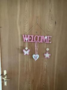 eine Tür mit einem Willkommensschild und Schmetterlingen drauf in der Unterkunft Chesa Islas, Wohnng 11 in Pontresina