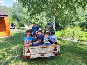 a group of children sitting in an old train at Domek nad stawem 