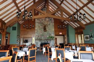 a dining room with tables and chairs and a fireplace at Turret House at Birchwood in Harbor Springs