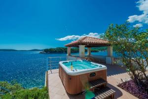 a hot tub on a patio next to the water at Villa Vacanza Dubrovnik - Five Bedroom Villa with Private Sea Access in Dubrovnik