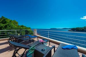Villa Vacanza Dubrovnik - Five Bedroom Villa with Private Sea Access في دوبروفنيك: شرفة مع كراسي وطاولة والمحيط
