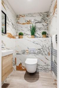 a bathroom with a toilet and a marble wall at The Coach House in Bournemouth