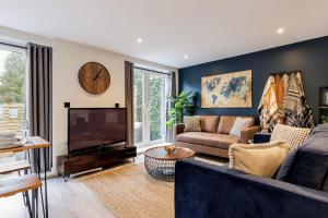 a living room with a couch and a tv at The Coach House in Bournemouth