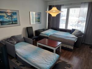 Pokój z 2 łóżkami, kanapą i stołem w obiekcie Apartment Skylights w mieście Rovaniemi