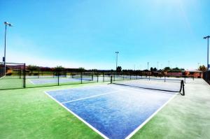 a tennis court with two tennis nets on it at Paradise Village 32 BBQ Grill, Foosball, Pink Pong, Nintendo Switch and a Resort Style Pool and Water Park in Santa Clara