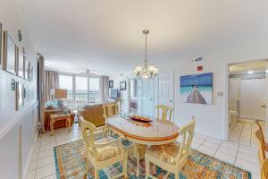 a dining room and living room with a table and chairs at Pelican Beach Resort 818 in Destin
