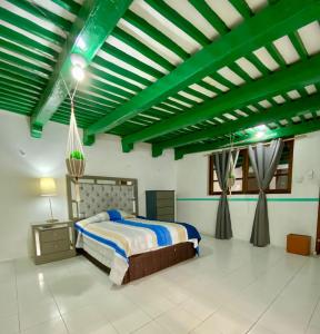 a bedroom with a bed and a green ceiling at Casa Colonial González in Mérida