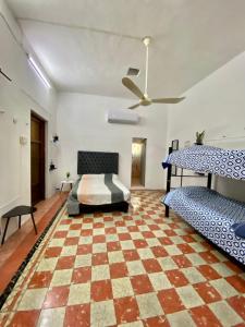 a bedroom with a bed and a checkered floor at Casa Colonial González in Mérida