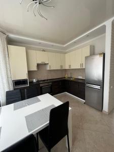 a kitchen with a table and a stainless steel refrigerator at Maxim in Vinnytsya