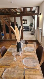 a long wooden table with wine glasses on it at Duplex de Prestige in Troyes